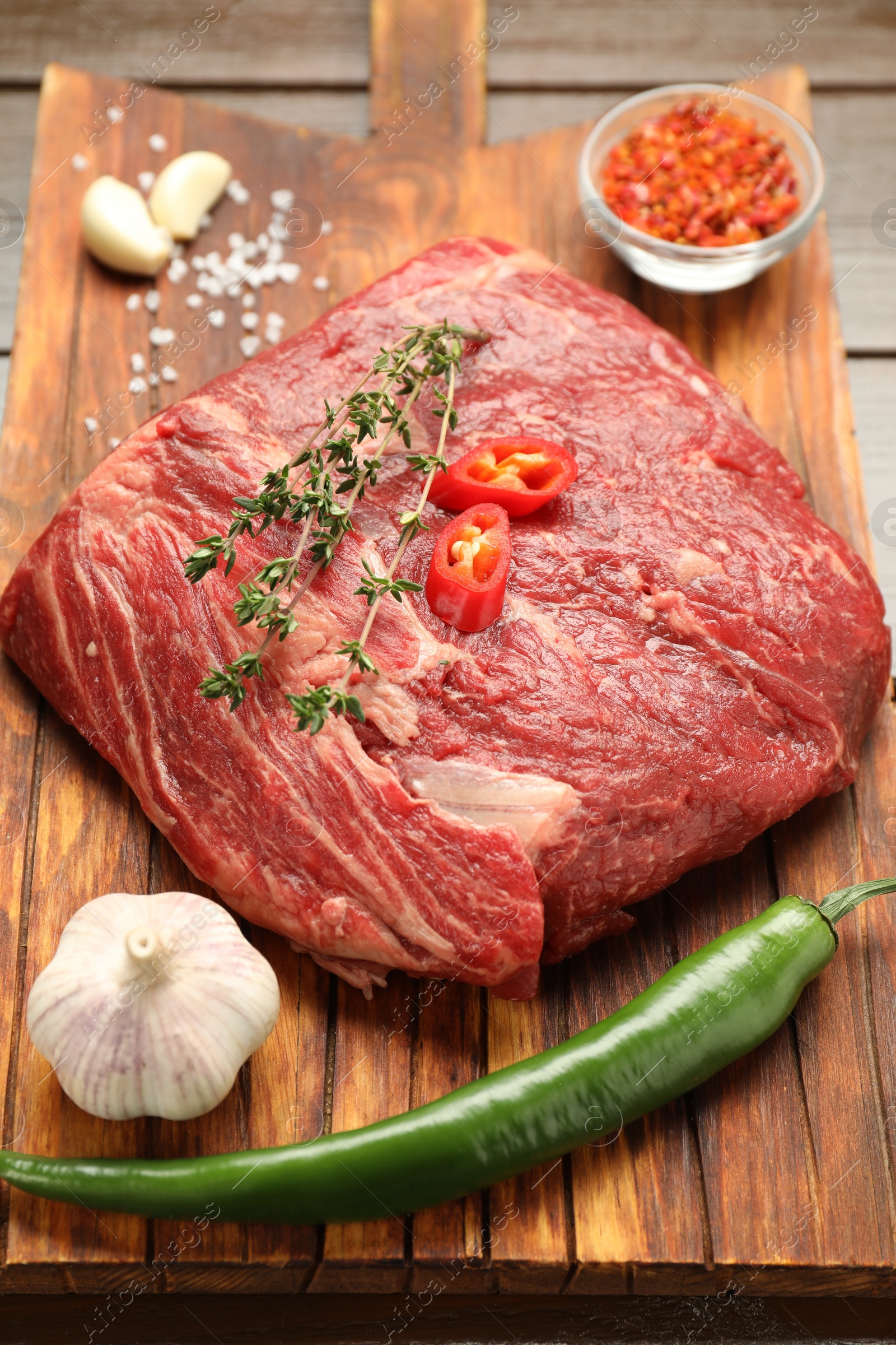 Photo of Fresh raw beef cut with spices on table