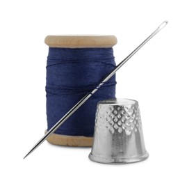 Photo of Thimble and spool of blue sewing thread with needle isolated on white