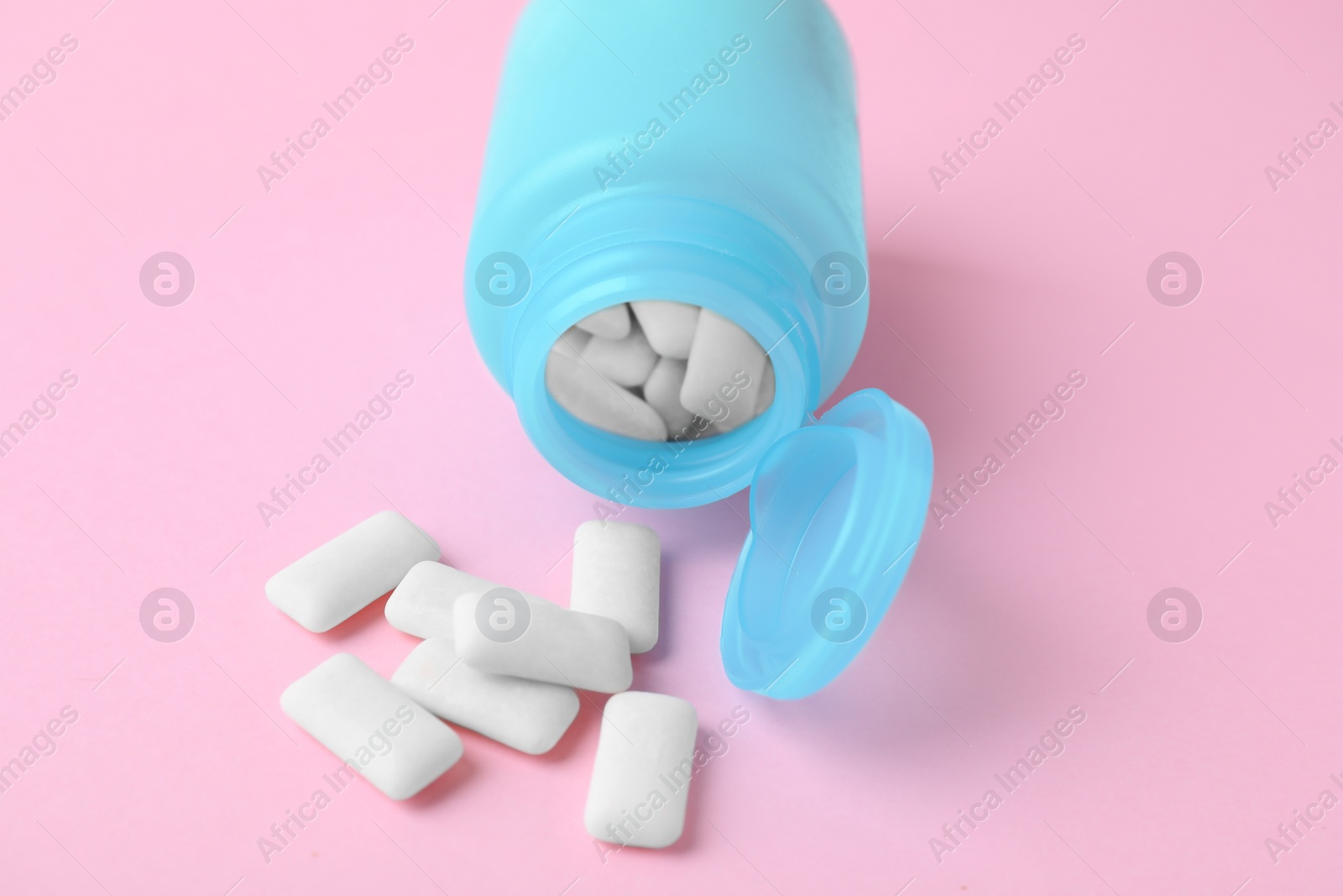 Photo of Jar with chewing gums on pink background, closeup