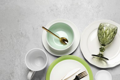 Photo of Beautiful ceramic dishware, cup, glass and cutlery on light grey table, flat lay