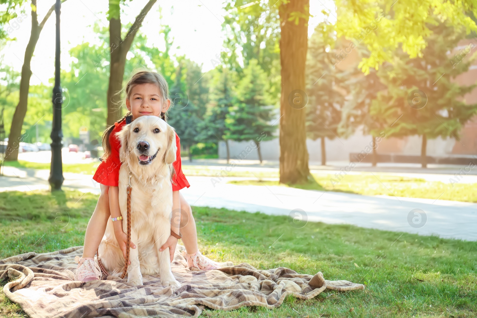 Photo of Cute little child with his pet in green park