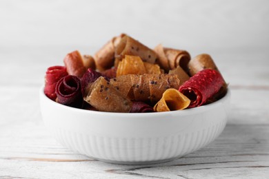 Delicious fruit leather rolls on white wooden table