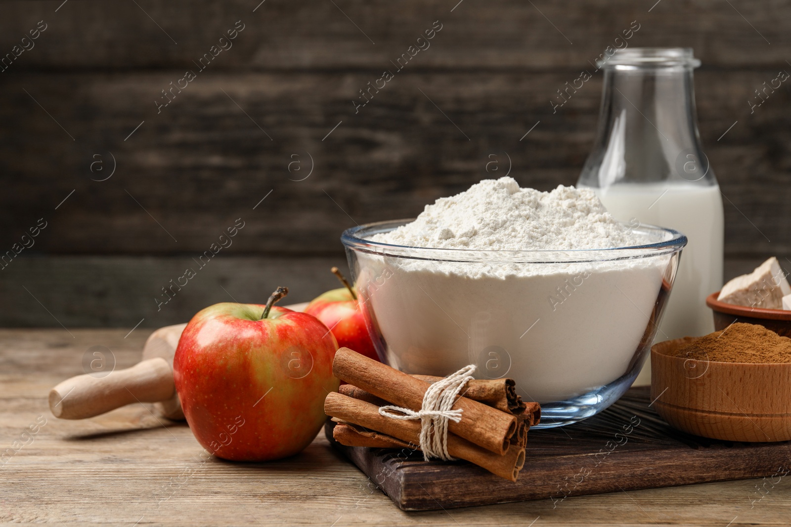 Photo of Flour, milk and different ingredients on wooden table. Yeast pastry