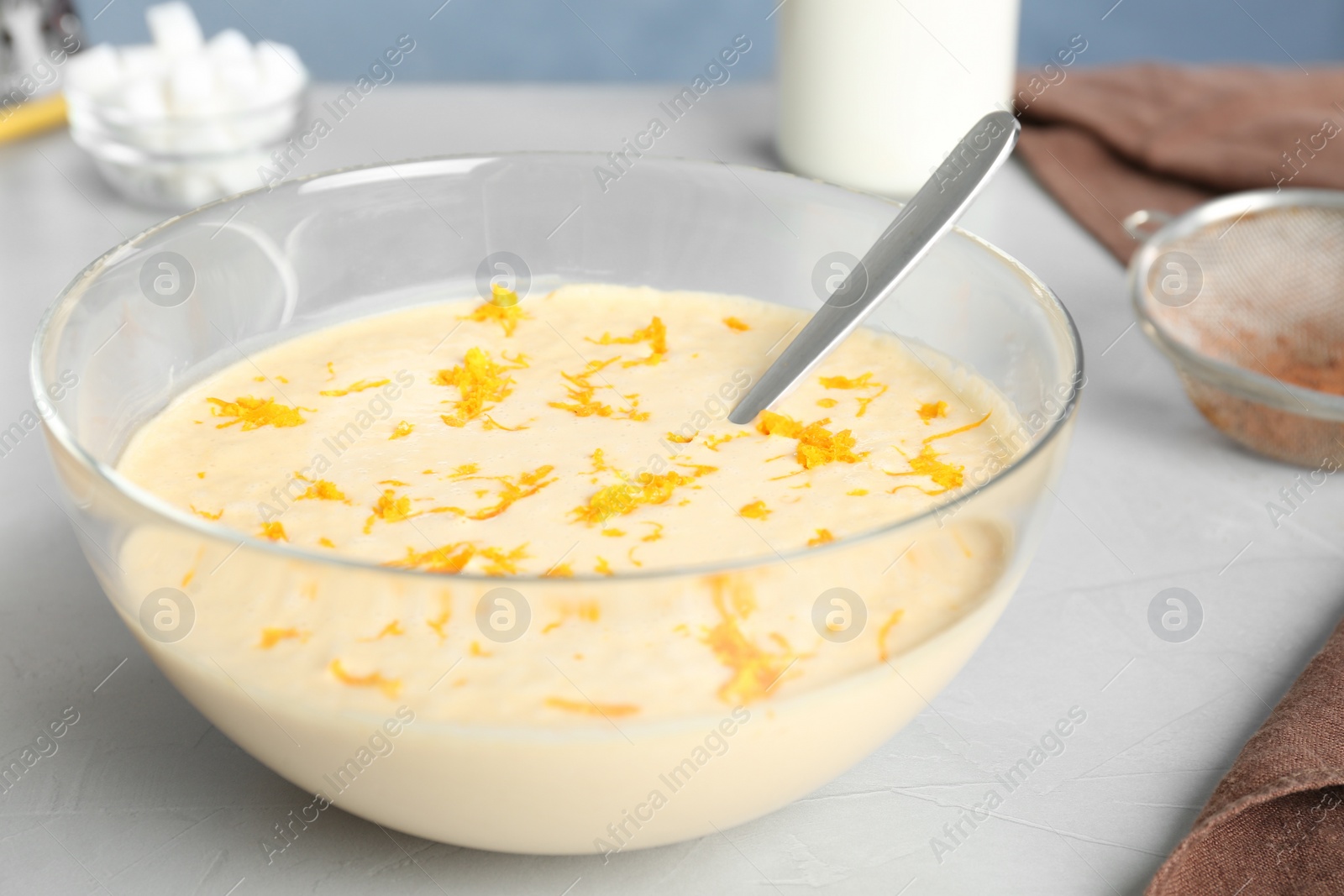 Photo of Glass bowl with batter on light table in kitchen, closeup