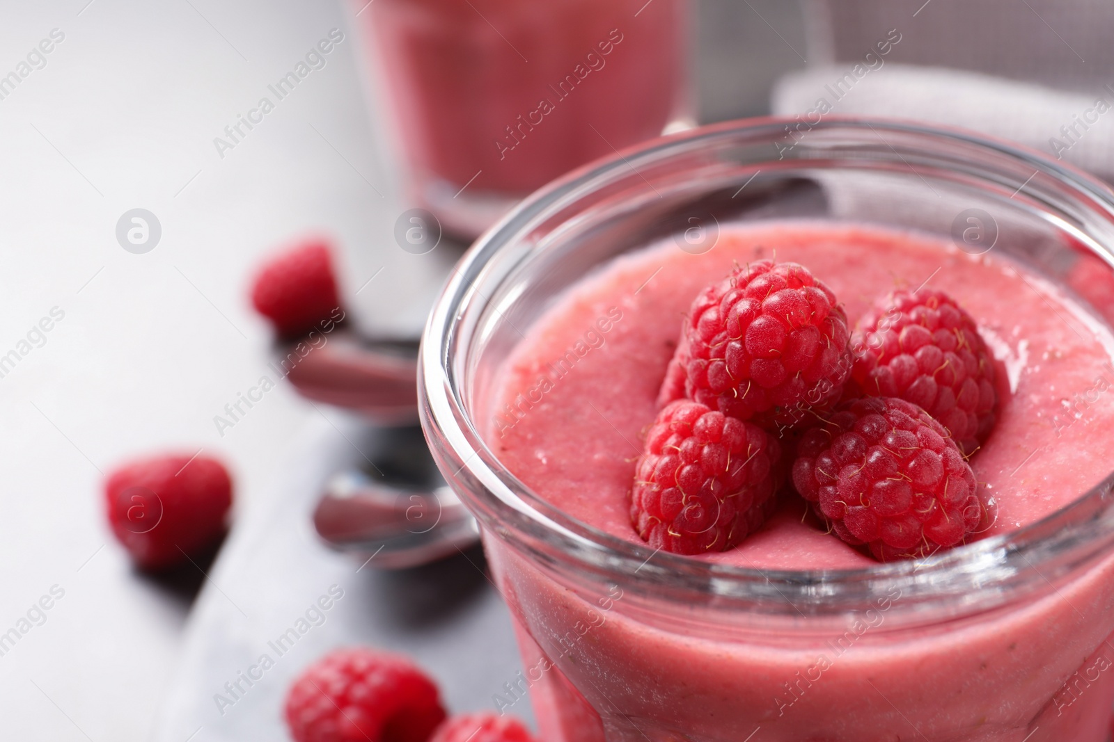 Photo of Delicious raspberry mousse in glass, closeup. Space for text