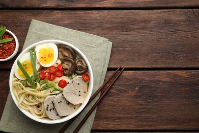 Delicious ramen with meat in bowl served on wooden table, flat lay. Space for text. Noodle soup