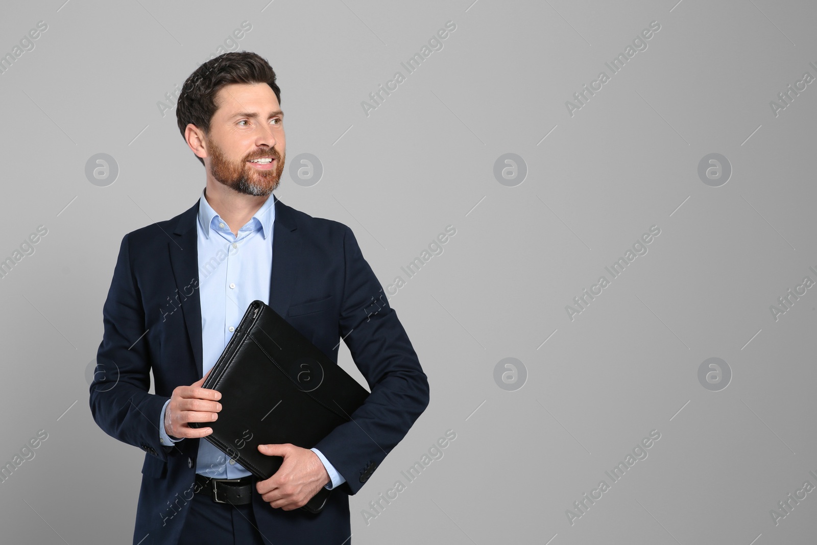 Photo of Handsome real estate agent with documents on grey background, space for text