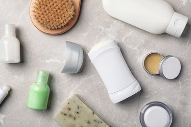 Photo of Flat lay composition with deodorant and toiletries on grey background