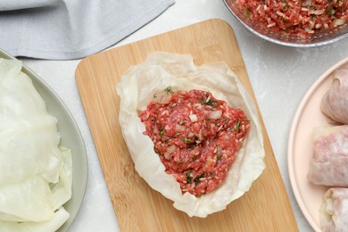 Preparing stuffed cabbage rolls on light grey table, flat lay