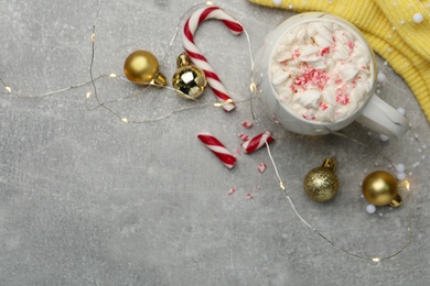 Flat lay composition with delicious marshmallow drink, festive decor and yellow sweater on light grey table. Space for text