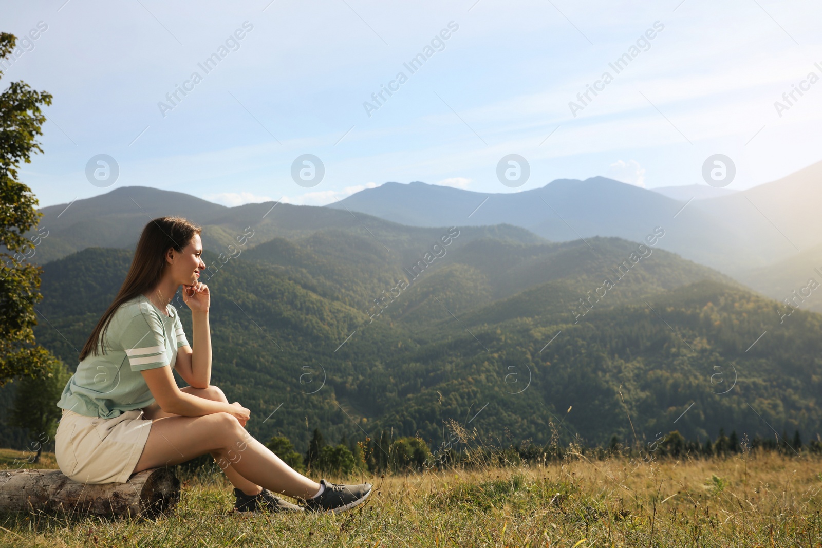 Photo of Young woman enjoying beautiful mountain landscape on sunny day