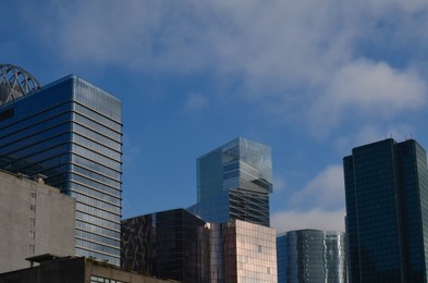 Photo of Exterior of different modern skyscrapers against blue sky