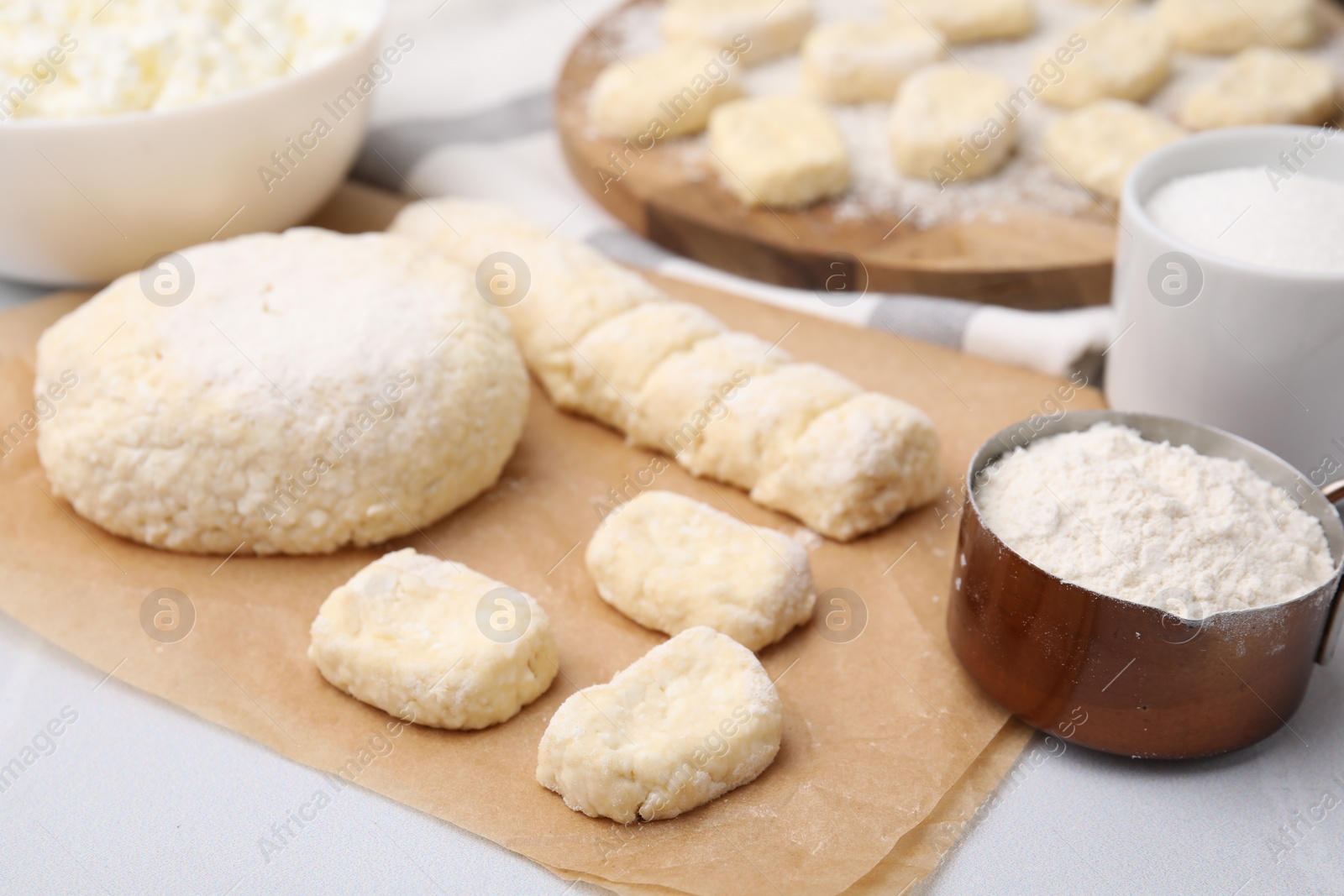 Photo of Making lazy dumplings. Raw dough and flour on white table, closeup