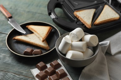 Photo of Ingredients for delicious sandwich with marshmallows and chocolate on grey wooden table, closeup