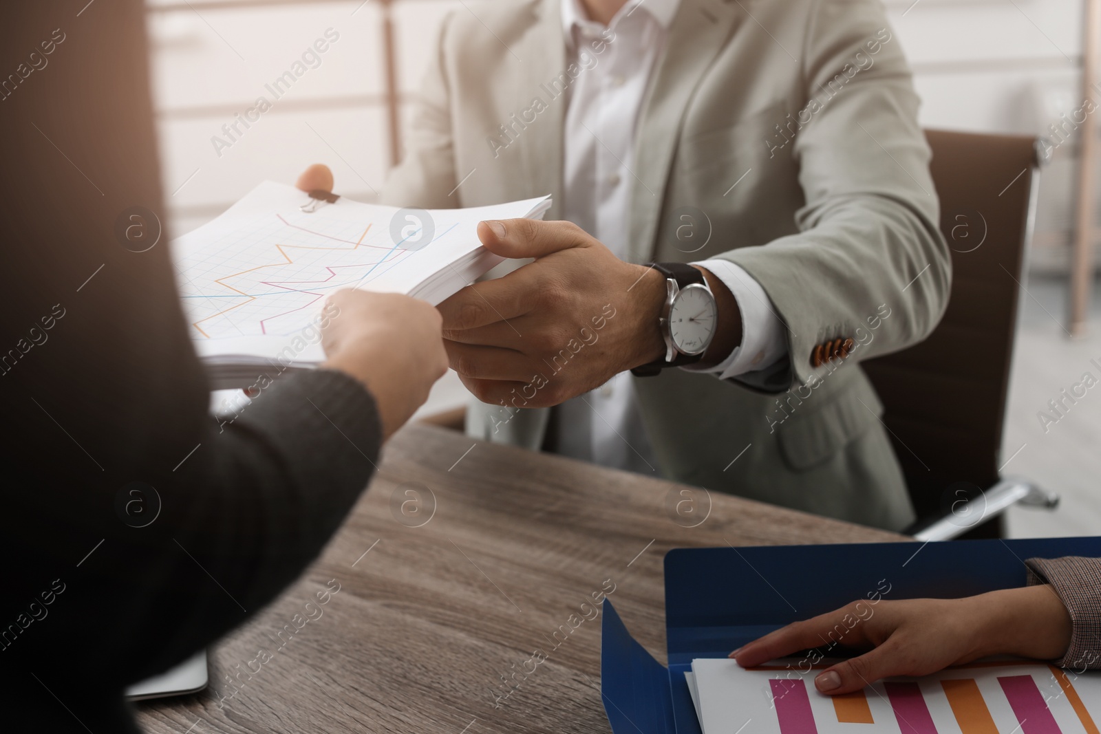 Photo of Office employees working with documents at table, closeup