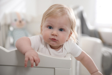 Adorable little baby in crib at home