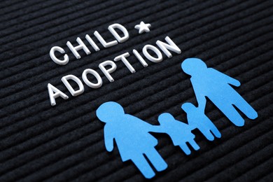 Photo of Family figure and phrase Child Adoption on black letter board