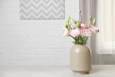 Photo of Beautiful flowers in vase and space for text on blurred background. Element of interior design