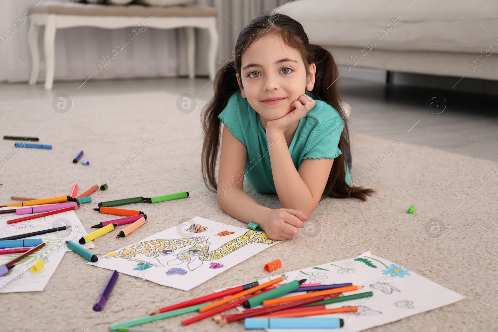 Photo of Cute child coloring drawing on floor at home