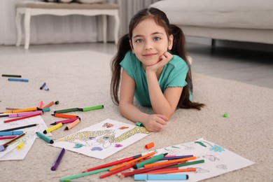 Cute child coloring drawing on floor at home