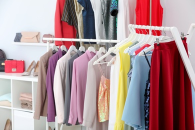 Photo of Racks with different stylish clothes in boutique