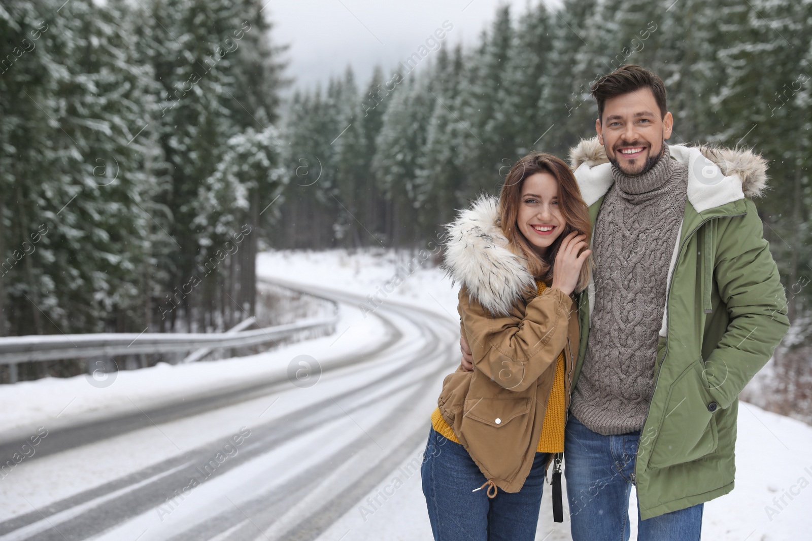 Photo of Couple walking near snowy forest, space for text. Winter vacation