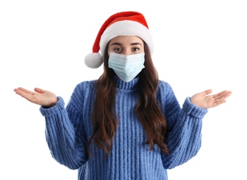 Photo of Beautiful woman wearing Santa Claus hat and medical mask on white background