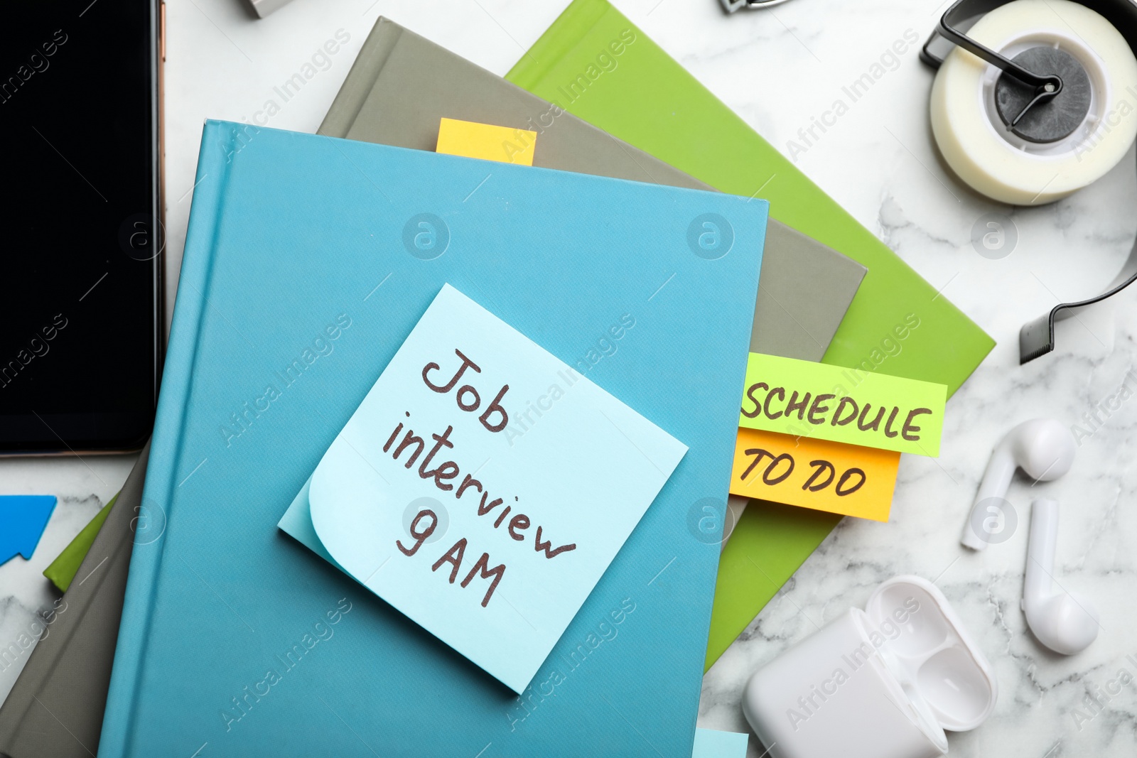 Photo of Reminder note about job interview and stationery on table, flat lay