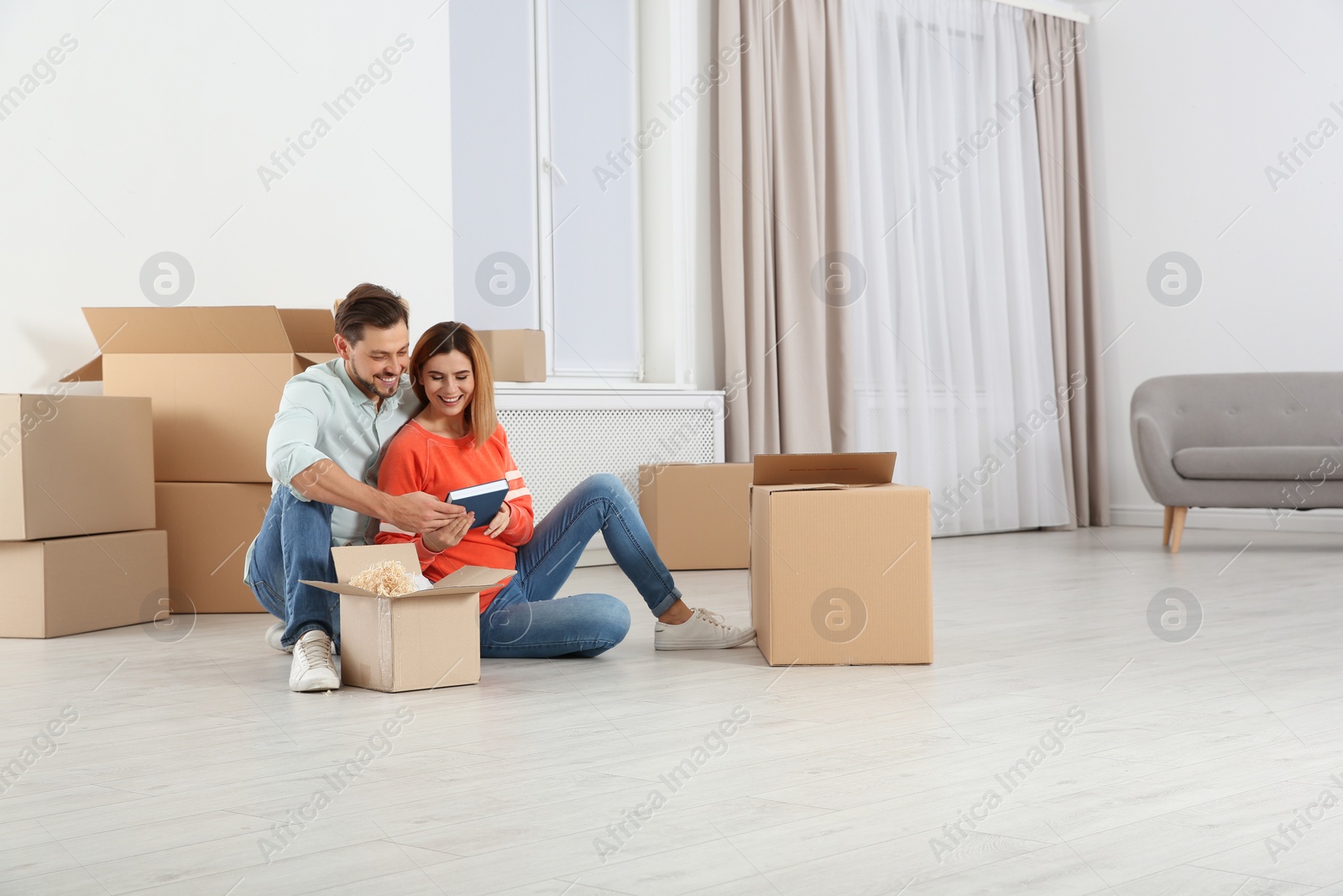 Photo of Couple unpacking moving boxes in their new house