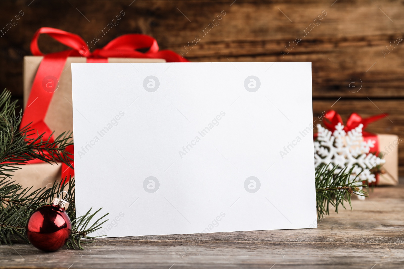 Photo of Blank Christmas card and festive decor on wooden table, closeup. Space for text