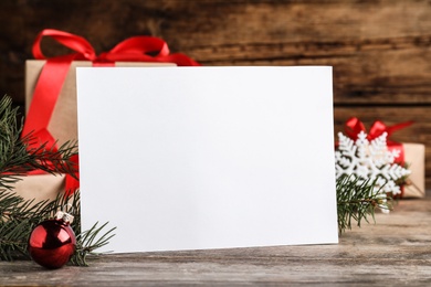 Blank Christmas card and festive decor on wooden table, closeup. Space for text