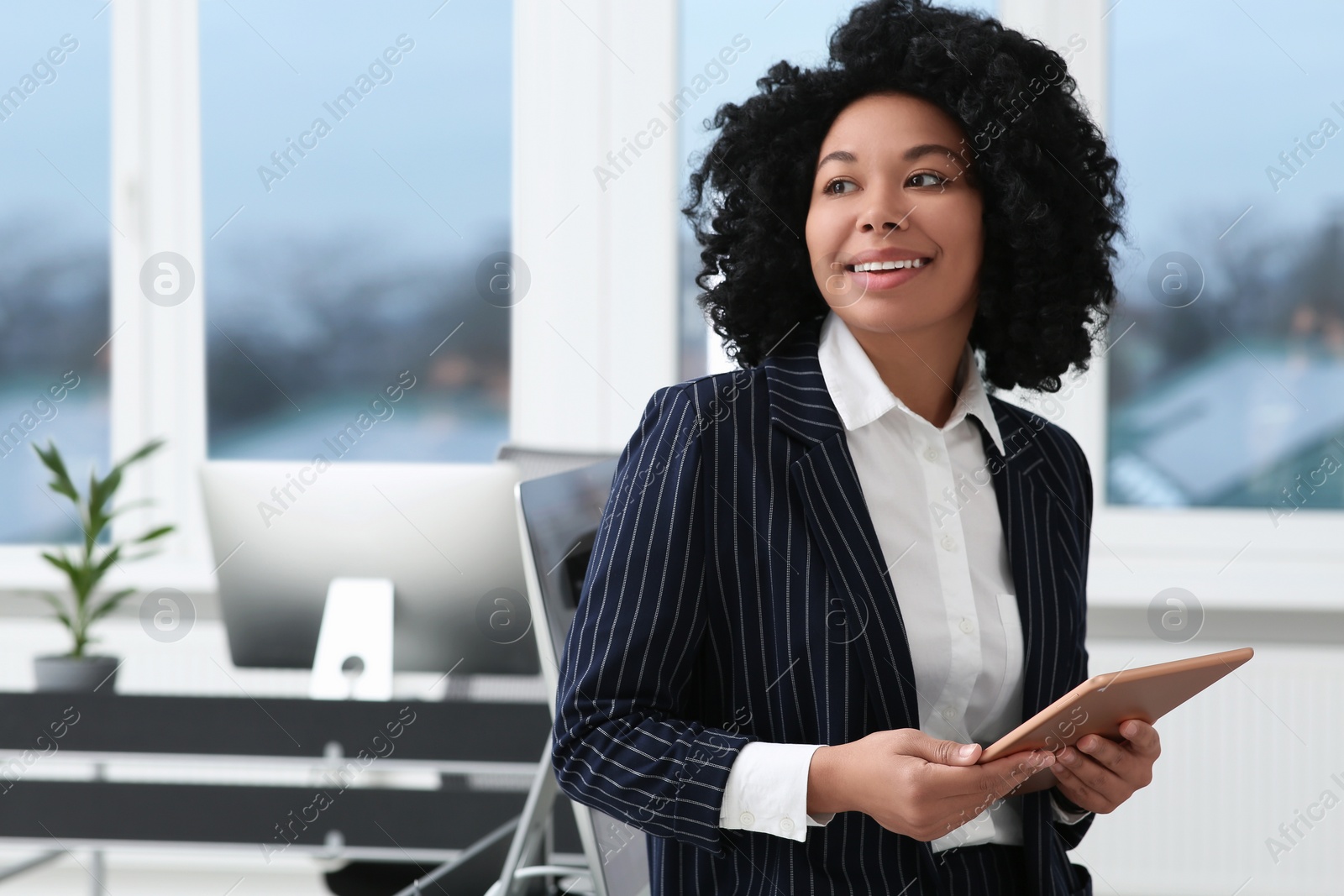 Photo of Smiling young businesswoman using tablet in office. Space for text