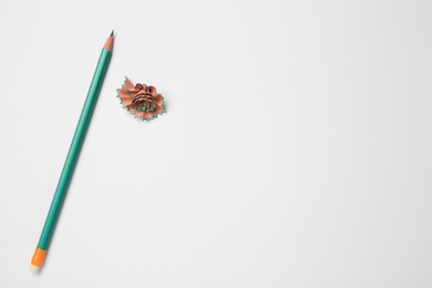 Photo of Graphite pencil and shavings on white background, flat lay. Space for text