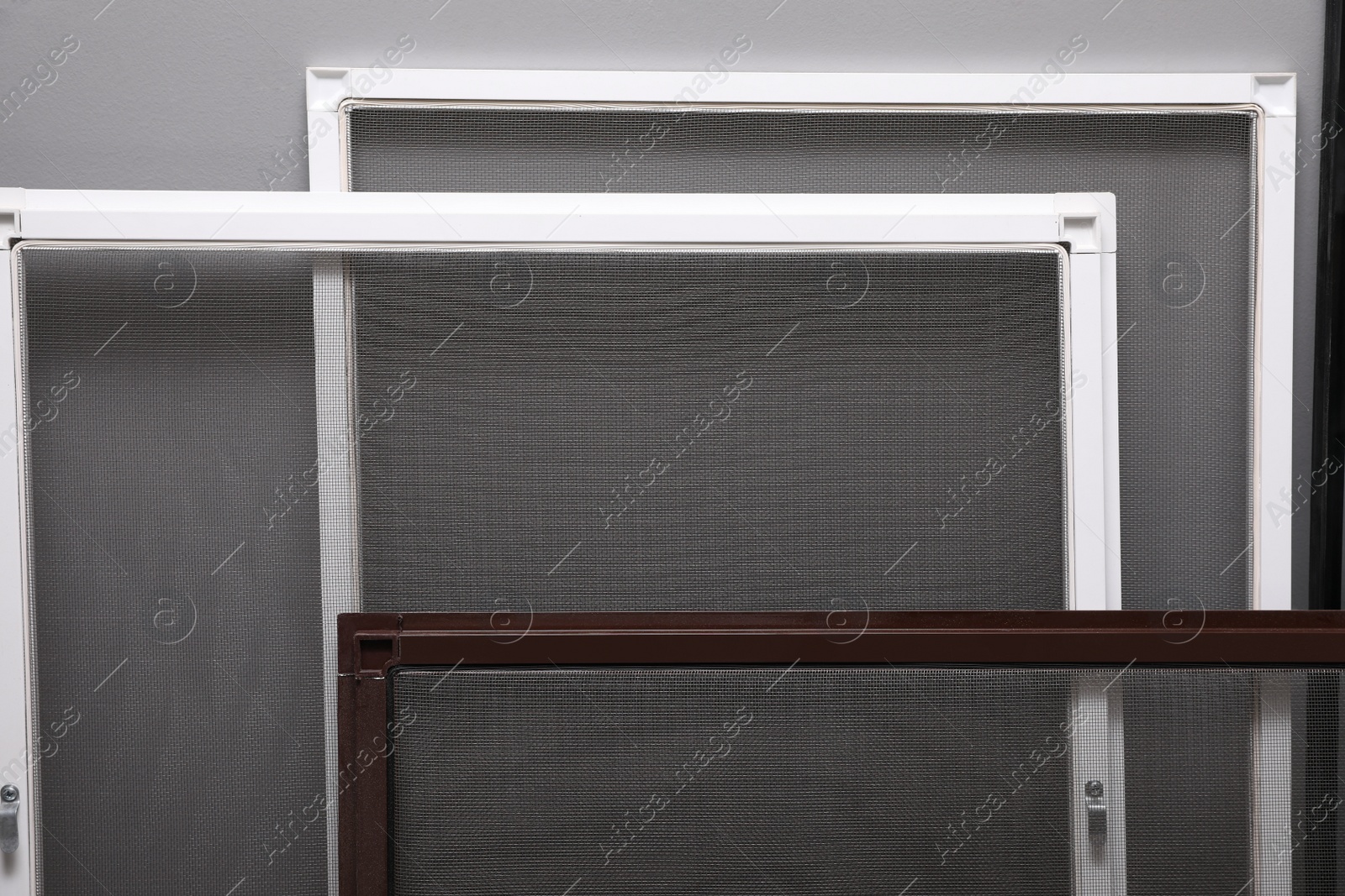 Photo of Mosquito window screens near grey wall, closeup