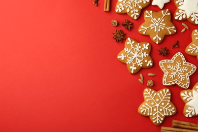 Photo of Tasty star shaped Christmas cookies with icing and spices on red background, flat lay. Space for text