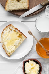 Photo of Glass with fresh milk, honey, butter and bread on white wooden table, flat lay