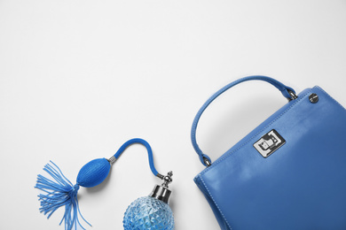 Stylish purse and perfume bottle on white background, top view. Classic blue - color of the Year 2020