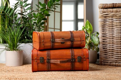 Photo of Beautiful brown stylish suitcases on carpet indoors