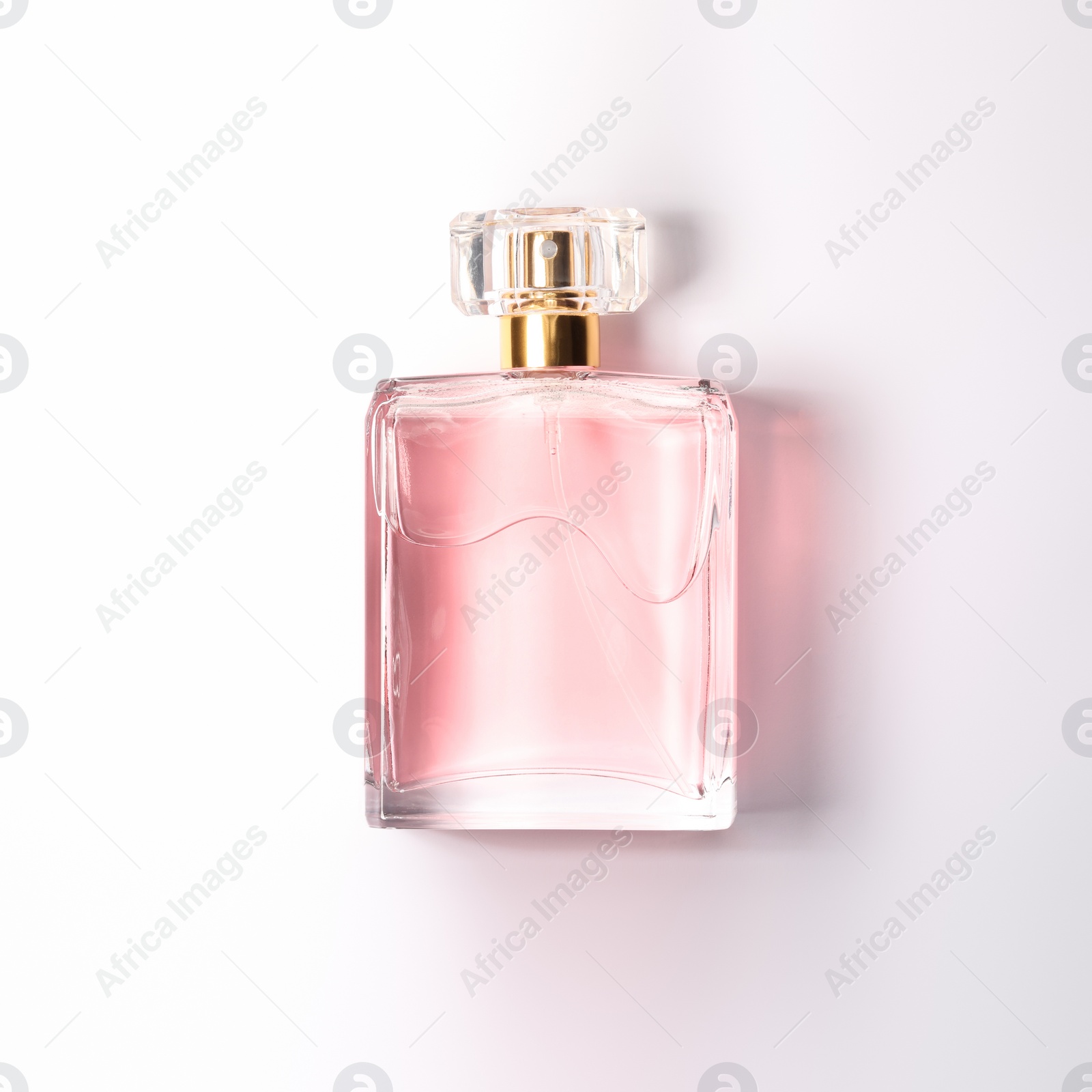 Photo of Pink women's perfume in bottle on white background, top view