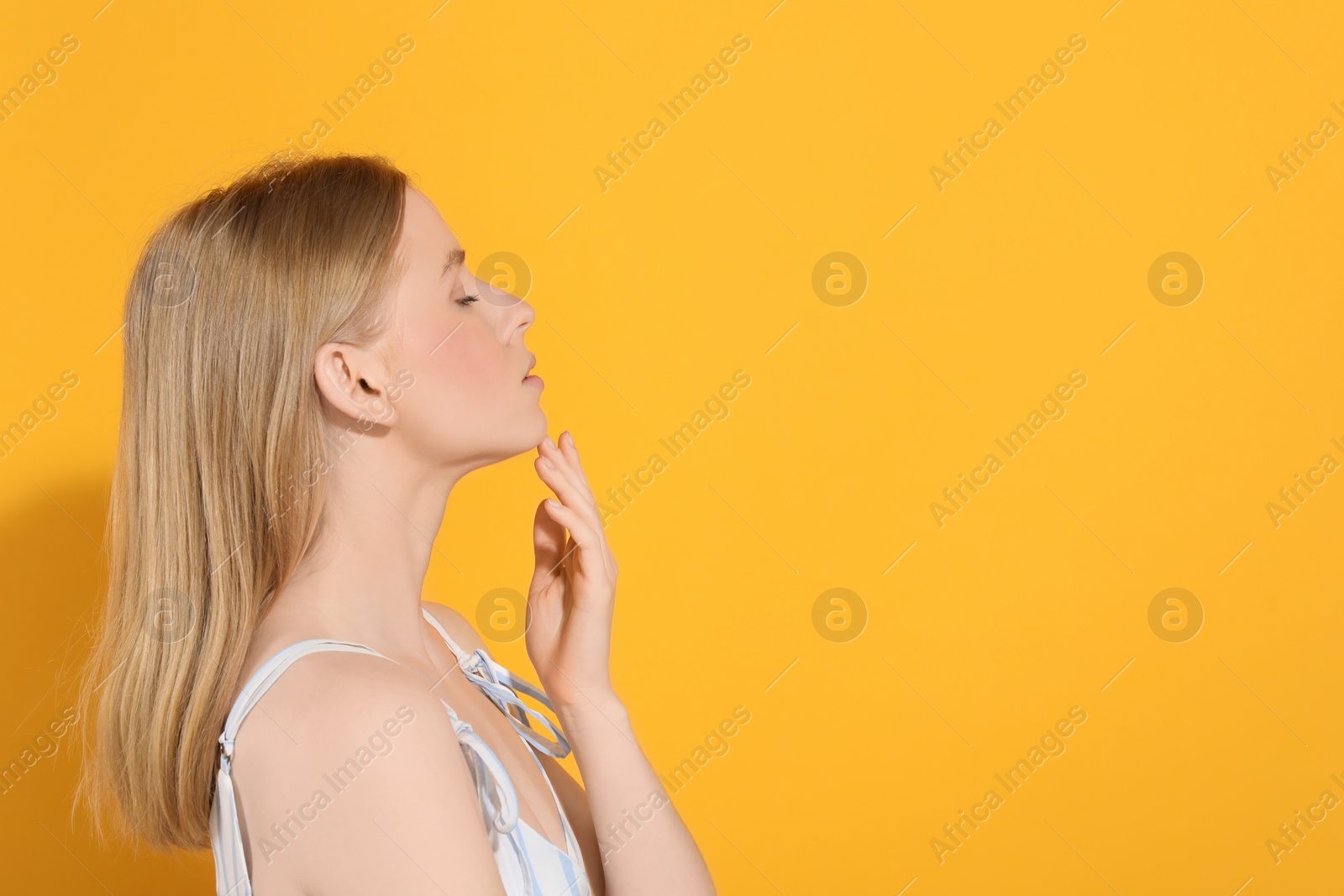 Photo of Beautiful young woman posing on orange background, space for text