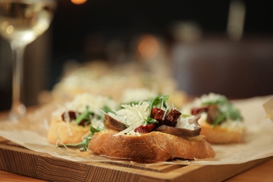 Delicious bruschettas with beef and cheese on table, closeup