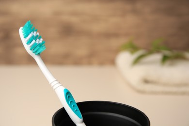 Photo of Toothbrush in holder on blurred background, closeup. Space for text