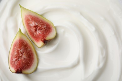 Tasty yogurt with cut fig as background, top view. Space for text