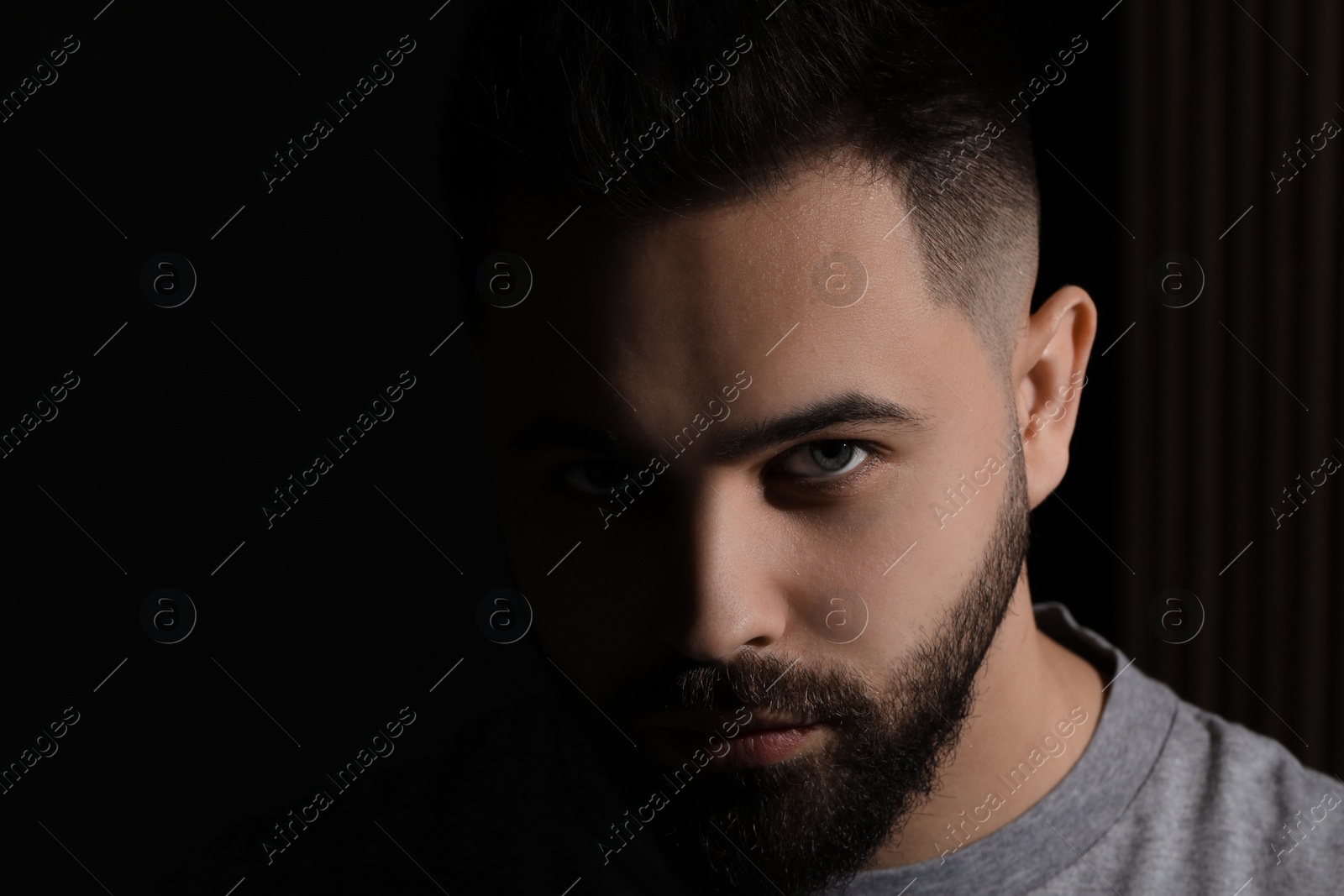 Photo of Evil eye. Man with scary eyes on black background, space for text