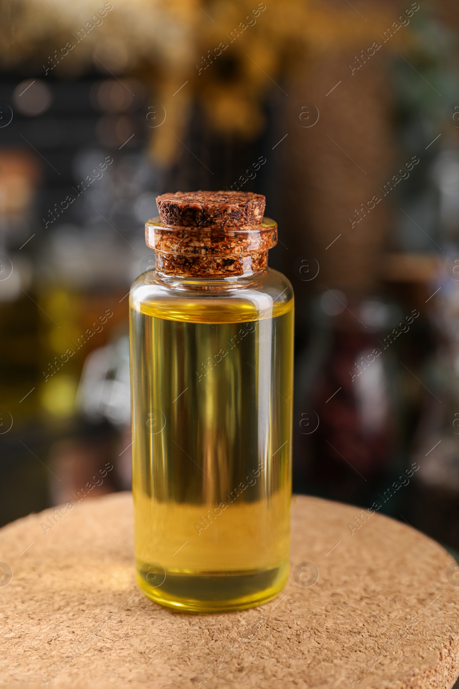 Photo of Bottle with herbal essential oils on blurred background, closeup