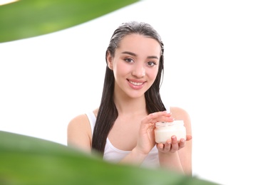 Young woman applying hair mask on white background