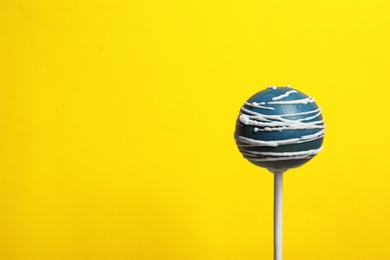 Bright delicious cake pop on color background. Space for text