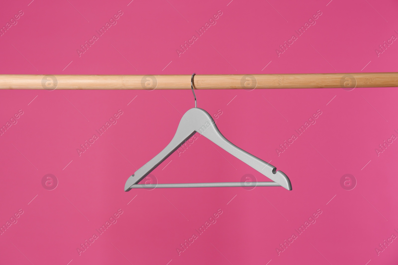 Photo of Wooden rack with clothes hanger on color background