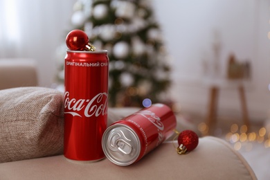 MYKOLAIV, UKRAINE - JANUARY 13, 2021: Cans of Coca-Cola and red Christmas balls indoors