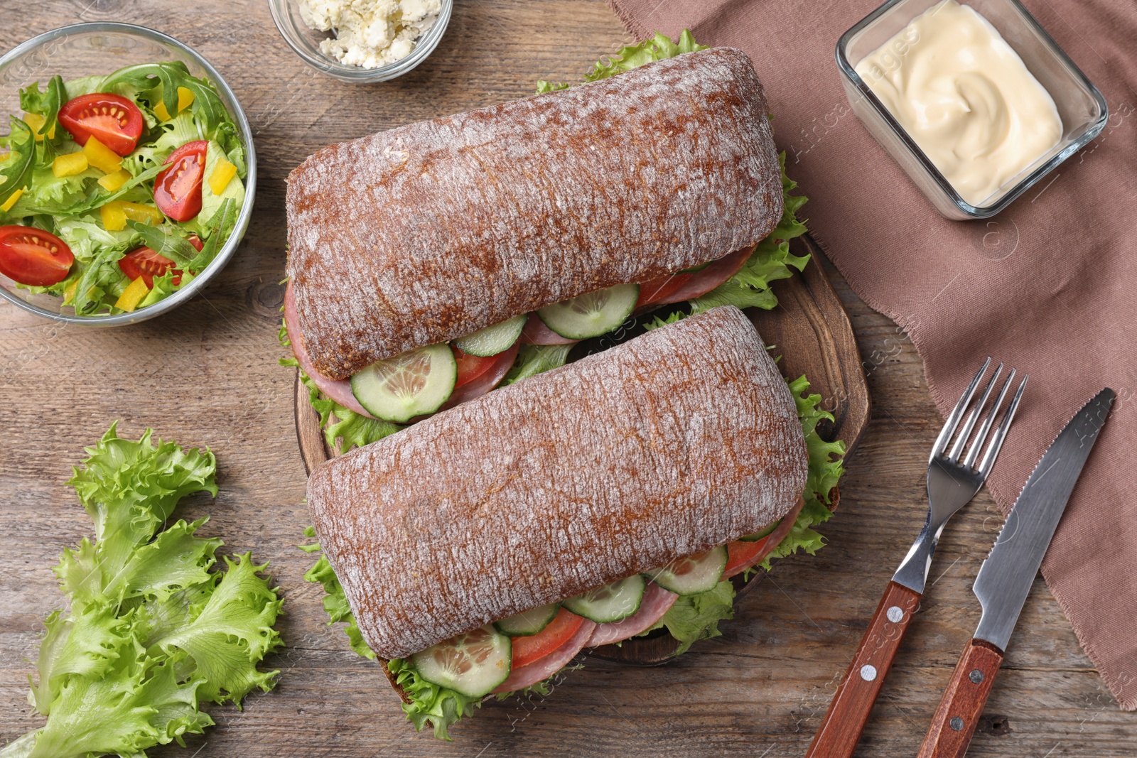 Photo of Tasty sandwiches with ham served on wooden table, flat lay